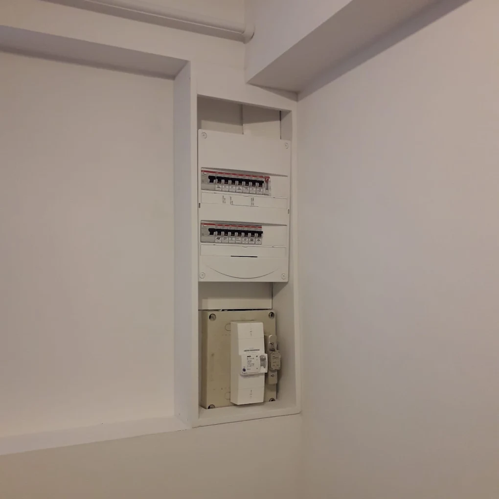 Tableau électrique encastré remis au propre dans une niche murale après installation du chauffe-eau