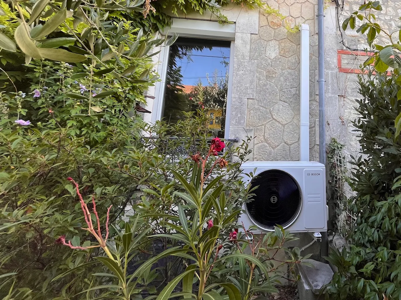 Unité extérieure de pompe à chaleur air/eau installée le long d'une maison